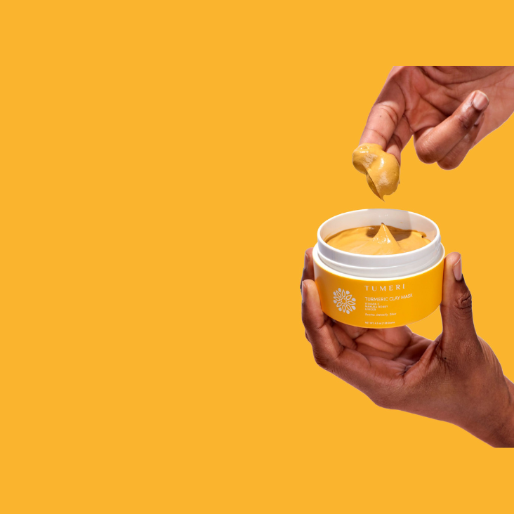 tumeric clay mask with hand applying
